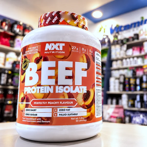 A tub of NXT beef protein isolate, peach flavour, on the shop counter